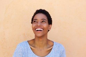 Smiling woman in light blue top, dental patient testimonial photo
