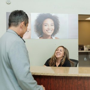 Dental professional showing patient dental X-ray or scan on computer monitor during consultation