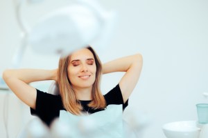 Relaxed woman with hands behind head in comfortable medical or dental office setting